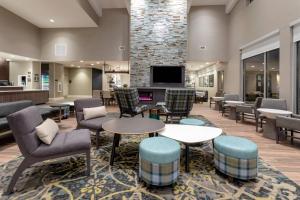 a lobby with tables and chairs and a tv at Residence Inn by Marriott St. Cloud in Waite Park