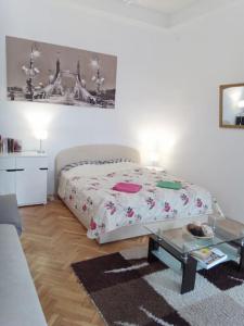 Schlafzimmer mit einem Bett und einem Glastisch in der Unterkunft Sunshine flat at the BLAHA in Budapest