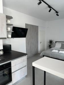a white kitchen with a bed and a white table at A drop from the sea in Finikas