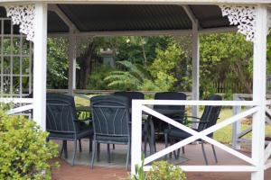 a group of chairs sitting under a gazebo at Oude Post Guesthouse and Cottage - The Old Postmaster's House in Lydenburg