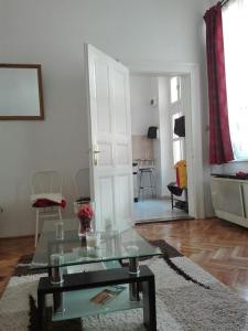 ein Wohnzimmer mit einem Glastisch und einer Tür in der Unterkunft Sunshine flat at the BLAHA in Budapest