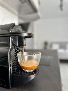 Una cafetera está vertiendo café en un tazón de cristal en A drop from the sea, en Finikas