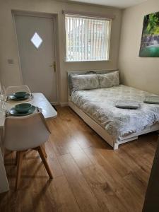 a bedroom with a bed and a table and a chair at Self-contained annex with private entrance, double bed, kitchen, bathroom, free car park - Near Cambridge, Duxford Air Museum and Addenbrooke's Hospital in Cambridge