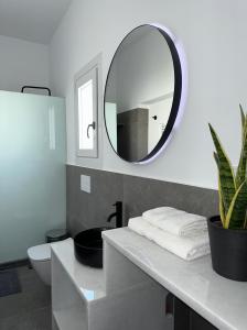 baño con lavabo y espejo en la pared en A drop from the sea, en Finikas