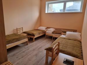a room with three beds and a window at Apgyvendinimo įstaiga KORNEALITA in Zarasai +7 photos