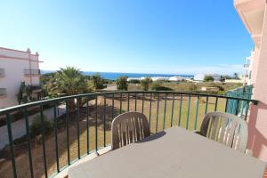 a balcony with a table and chairs and the ocean at Luz Casas - St James 116, 2Bed/2Bath, Air Con, Shared Pool, Sea View in Luz