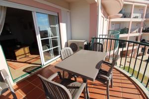 a balcony with a table and chairs on a balcony at Luz Casas - St James 116, 2Bed/2Bath, Air Con, Shared Pool, Sea View in Luz