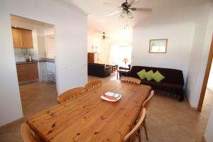 a living room with a wooden table and a couch at Luz Casas - St James 116, 2Bed/2Bath, Air Con, Shared Pool, Sea View in Luz +16 photos