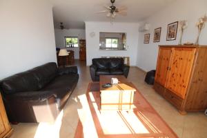 een woonkamer met een zwarte leren bank en een tafel bij Luz Casas - St James 116, 2Bed/2Bath, Air Con, Shared Pool, Sea View in Luz
