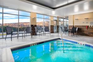 a swimming pool with chairs and a table and a dining room at Fairfield Inn & Suites by Marriott Klamath Falls in Klamath Falls