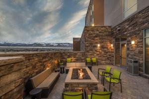 eine Terrasse mit einem Tisch, Stühlen und einem Kamin in der Unterkunft SpringHill Suites by Marriott Reno in Reno