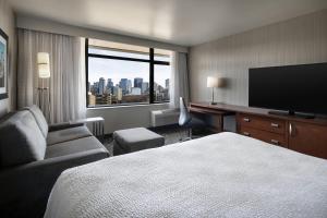 a hotel room with a bed and a flat screen tv at Courtyard Seattle Downtown/Lake Union in Seattle