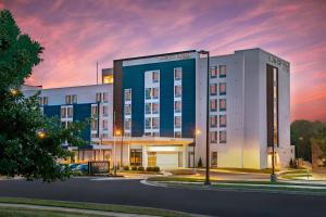 a hotel building with a sunset in the background at SpringHill Suites By Marriott Frederick in Frederick