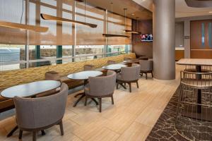 a dining room with tables and chairs and windows at SpringHill Suites By Marriott Frederick in Frederick