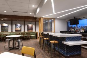 a restaurant with a bar and tables and chairs at Fairfield by Marriott Inn and Suites O Fallon IL in O'Fallon