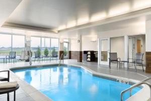 a large swimming pool with blue water in a building at Fairfield by Marriott Inn and Suites O Fallon IL in O'Fallon