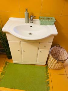 a bathroom with a white sink and a green rug at Apartment Ela Centre in Košice