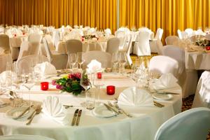 プルゼニにあるコートヤード バイ マリオット ピルセンの白いテーブルと白い椅子が備わる会議室