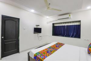 a bedroom with a bed and a black door at FabHotel Villa 31 in Nagpur