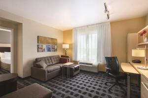 a hotel room with a couch and a desk at TownePlace Suites Joliet South in Joliet