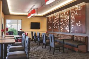 a restaurant with tables and chairs and a tv at TownePlace Suites Joliet South in Joliet