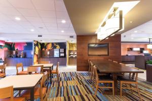 a dining room with tables and chairs and a tv at Fairfield Inn & Suites by Marriott Decorah in Decorah