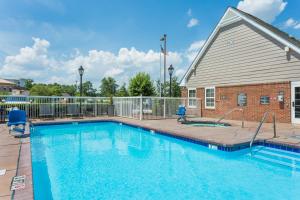 a swimming pool in front of a house at Residence Inn by Marriott Rocky Mount in Rocky Mount