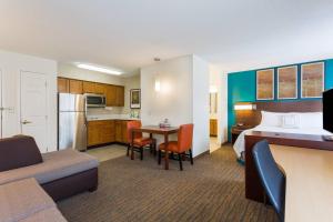 a hotel room with a bed and a table and a kitchen at Residence Inn by Marriott Rocky Mount in Rocky Mount