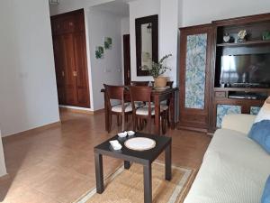 een woonkamer met een bank en een tafel bij casa pastora, la casa familiar in Conil de la Frontera