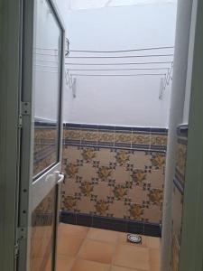 een badkamer met een douche en een glazen deur bij casa pastora, la casa familiar in Conil de la Frontera