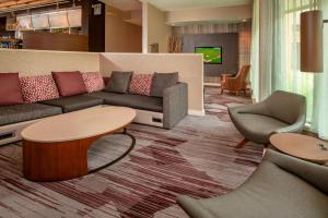 a living room with a couch and a table and chairs at Courtyard by Marriott Rockville in Rockville