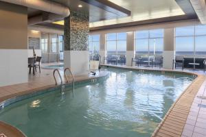 a large swimming pool in a hotel with a view of the ocean at Residence Inn By Marriott Virginia Beach Oceanfront in Virginia Beach