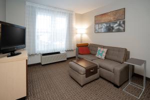 a living room with a couch and a flat screen tv at TownePlace Suites Rochester in Rochester