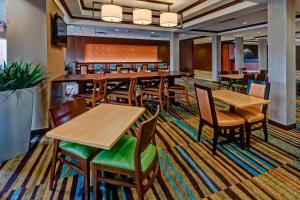 uma sala de jantar com mesas e cadeiras de madeira em Fairfield Inn and Suites by Marriott Oklahoma City Airport em Oklahoma City