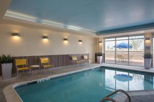 uma piscina num hotel com cadeiras e mesas em Fairfield Inn & Suites by Marriott Dallas West/I-30 em Dallas