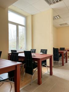 a conference room with wooden tables and chairs at Hostel Kornealita in Zarasai