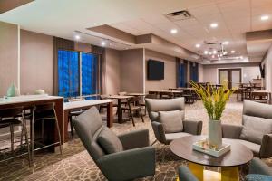 a conference room with tables and chairs and a tv at SpringHill Suites Indianapolis Carmel in Carmel