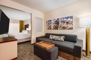 a living room with a couch and a bed at SpringHill Suites Indianapolis Carmel in Carmel