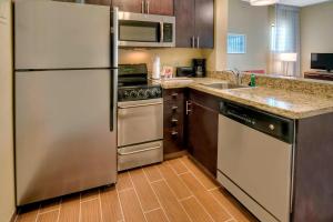 a kitchen with a stainless steel refrigerator and a sink at TownePlace Suites Oklahoma City Airport in Oklahoma City