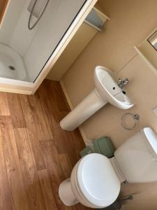 a bathroom with a toilet and a sink at Golden Palm Resort PG163 in Chapel Saint Leonards
