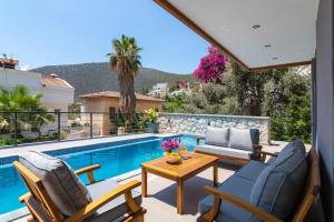 a patio with two chairs and a table next to a swimming pool at Gorgeous 3 Bedroom Property at Kalamar Bay in Kalkan