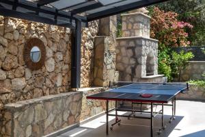 a ping pong table in front of a stone wall at Gorgeous 3 Bedroom Property at Kalamar Bay in Kalkan