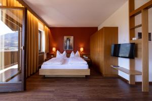 a hotel room with a bed and a flat screen tv at Residence Pollingerhof in Merano