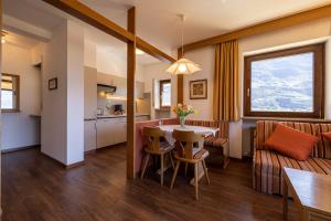 a kitchen and living room with a table and a couch at Residence Pollingerhof in Merano