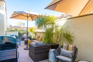 a patio with chairs and a grill and an umbrella at NEW! PGA West (Signature!) walk to Stadium Course! in La Quinta