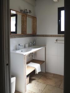 a white bathroom with a sink and a mirror at Songes d’été in Bonifacio