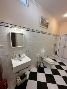 a bathroom with a black and white checkered floor at Residência Mendonça in Faial