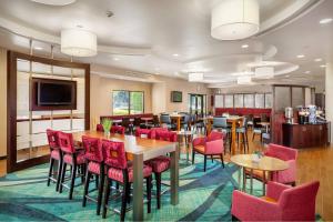 a dining room with tables and red chairs at SpringHill Suites by Marriott Modesto in Modesto