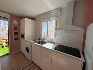a kitchen with a sink and a washing machine at Balcón al mediterráneo in Almuñécar