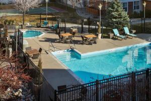 einen Pool mit Tischen und Stühlen neben einem Zaun in der Unterkunft Residence Inn Salt Lake City Cottonwood in Cottonwood Heights